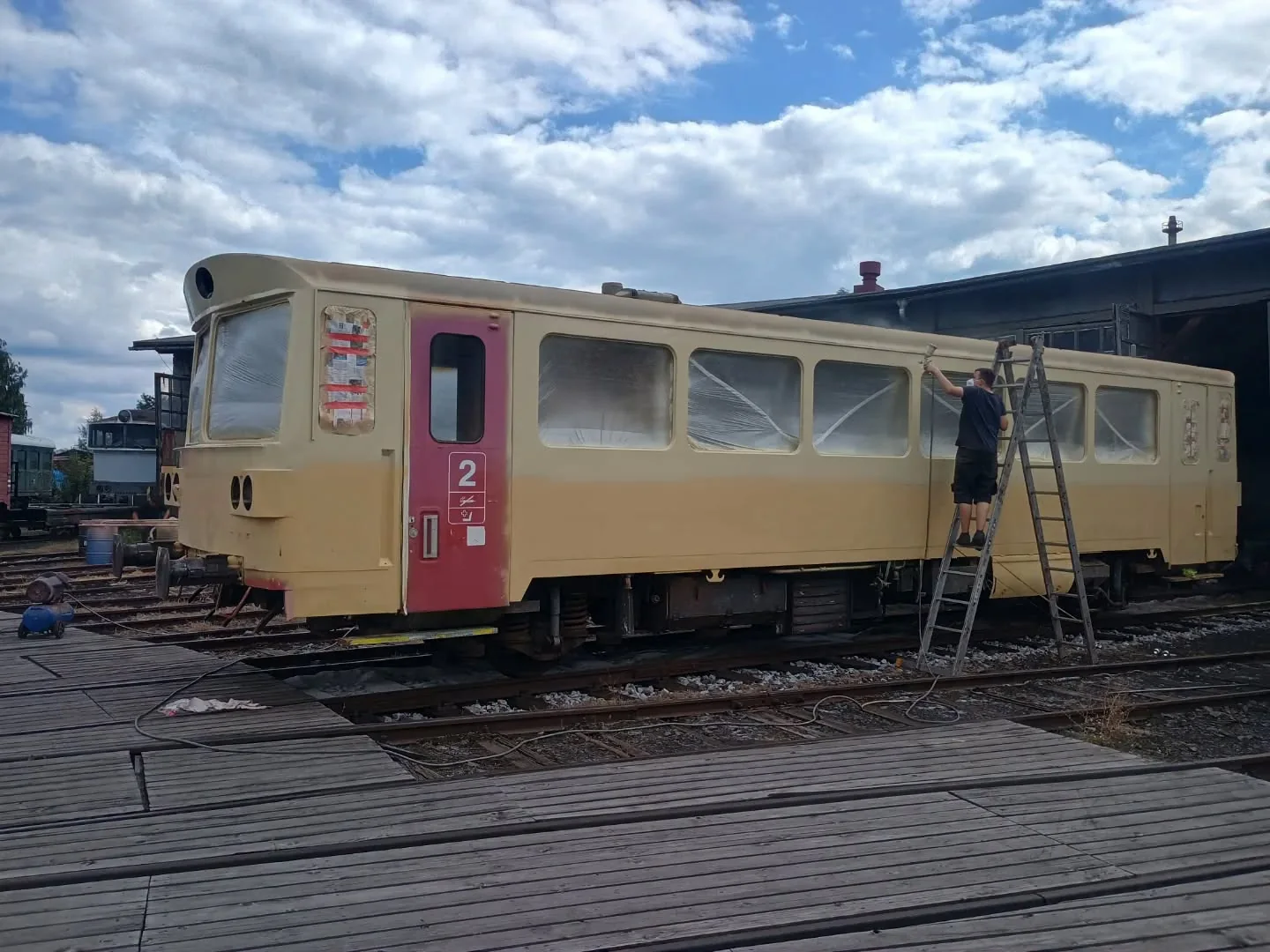 Práce na obnově nátěru historického motorového vozu v turnovském depu.
